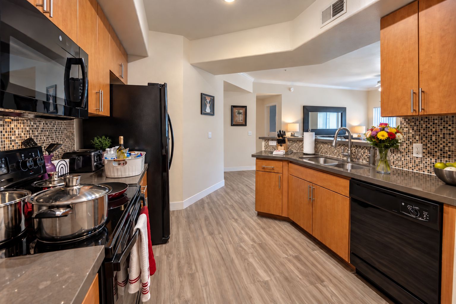 A modern kitchen with wooden cabinets, stainless steel appliances, and a tiled backsplash.