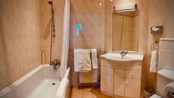 Un baño con bañera, lavamanos y ducha.