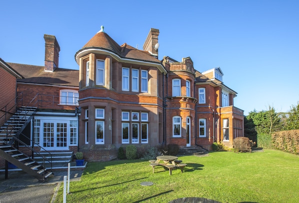 A large, brick house with a prominent turret and multiple windows.