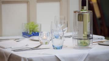 A table set with wine glasses, a bottle of wine, and a candle.