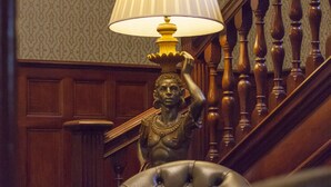 Een trap met een lamp en een standbeeld.