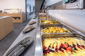A buffet with various food items and utensils.