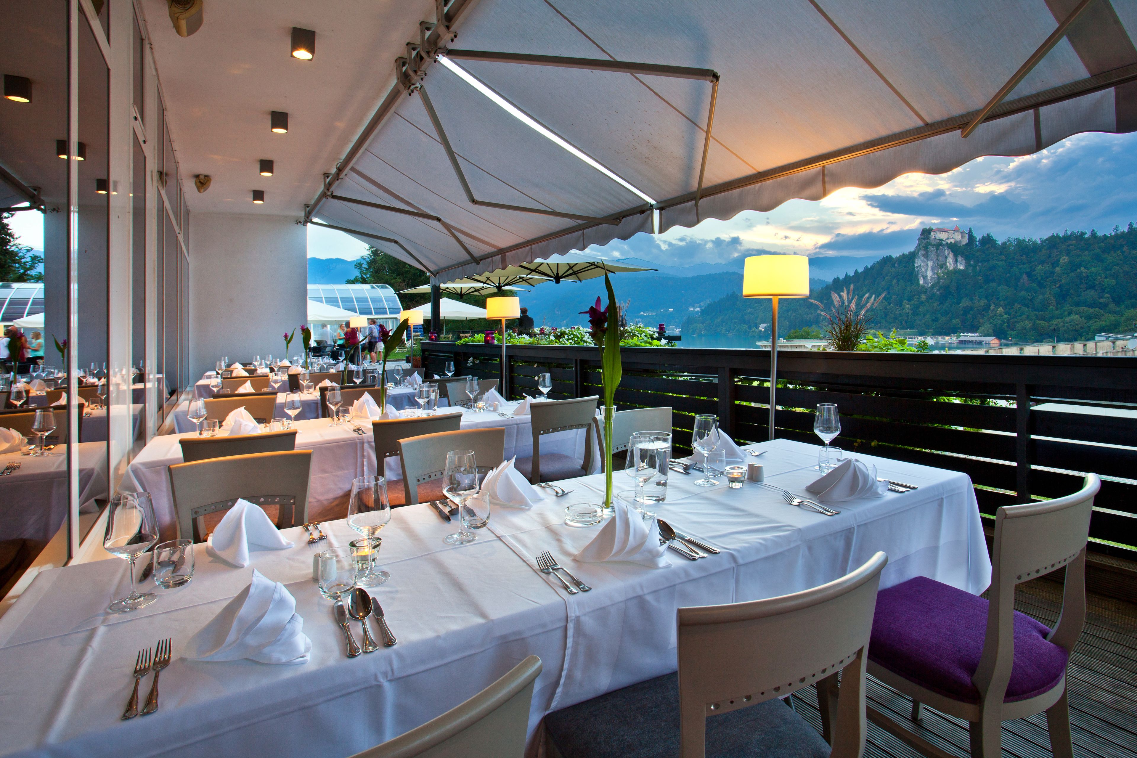 A restaurant with tables set for dining, overlooking a scenic mountain view.