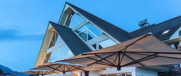Experience the unique triangular design and expansive windows of this contemporary building, featuring outdoor seating areas perfect for relaxation or dining.