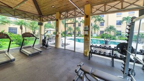 Un gimnasio con cintas de correr, mancuernas y un banco para pesas.