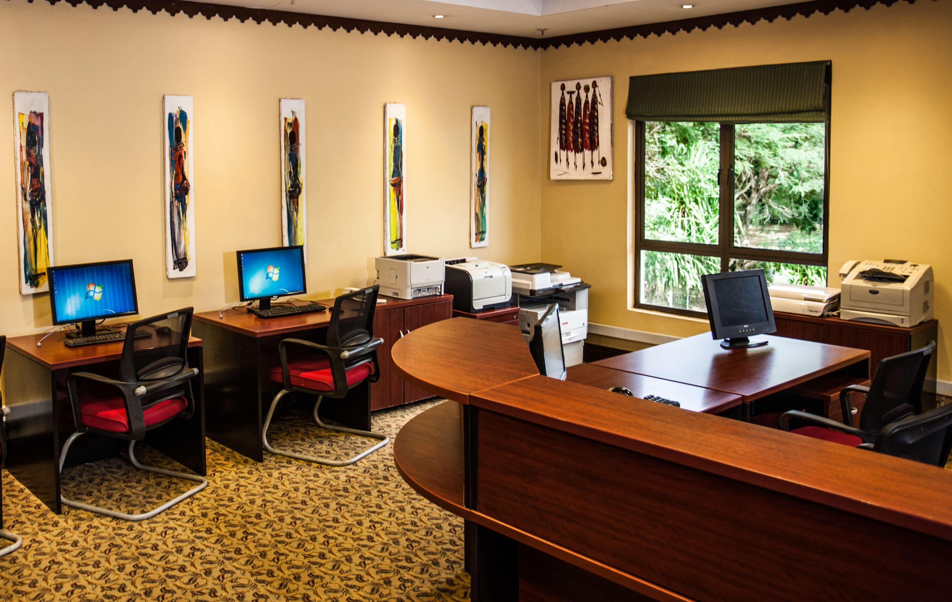 A conference room with multiple desks, chairs, and computer monitors.