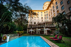 Una piscina al aire libre, sombrillas, tumbonas