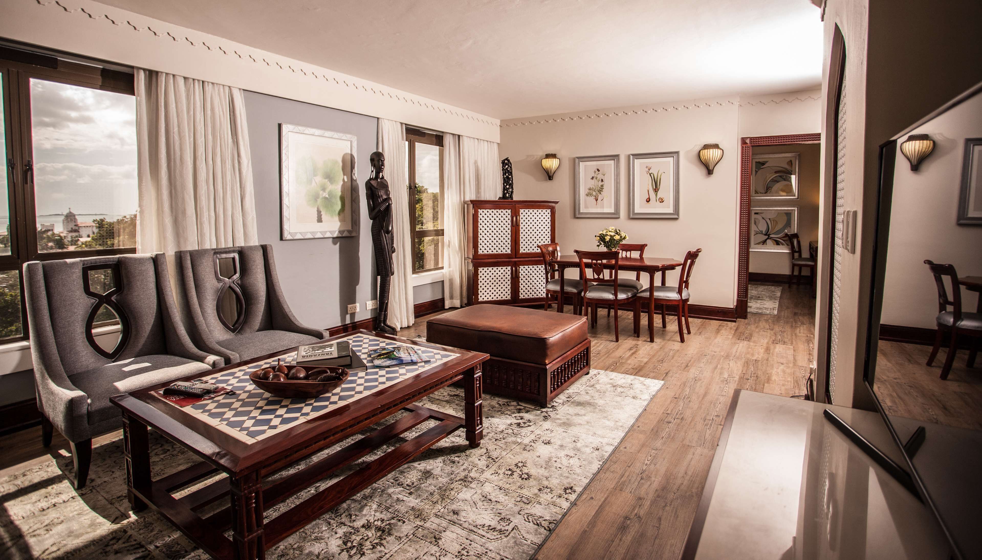 Un salón amplio con un ventanal grande, un sofá, una mesa de centro y un comedor.