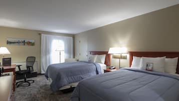 Ein Hotelzimmer mit zwei Betten, einem Schreibtisch, einem Stuhl und einem Nachttisch.