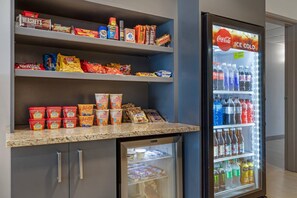 A snack bar with a variety of packaged snacks, a refrigerator stocked with beverages, and a microwave. - Comfort Inn & Suites Rochester South Mayo Clinic (Rochester)