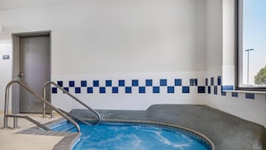 An indoor swimming pool with a checkered tile wall, a door labeled 'Mechanical Room,' and a window with a view outside.