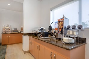 A kitchen with a waffle maker, a waffle iron, and a waffle maker instruction manual.