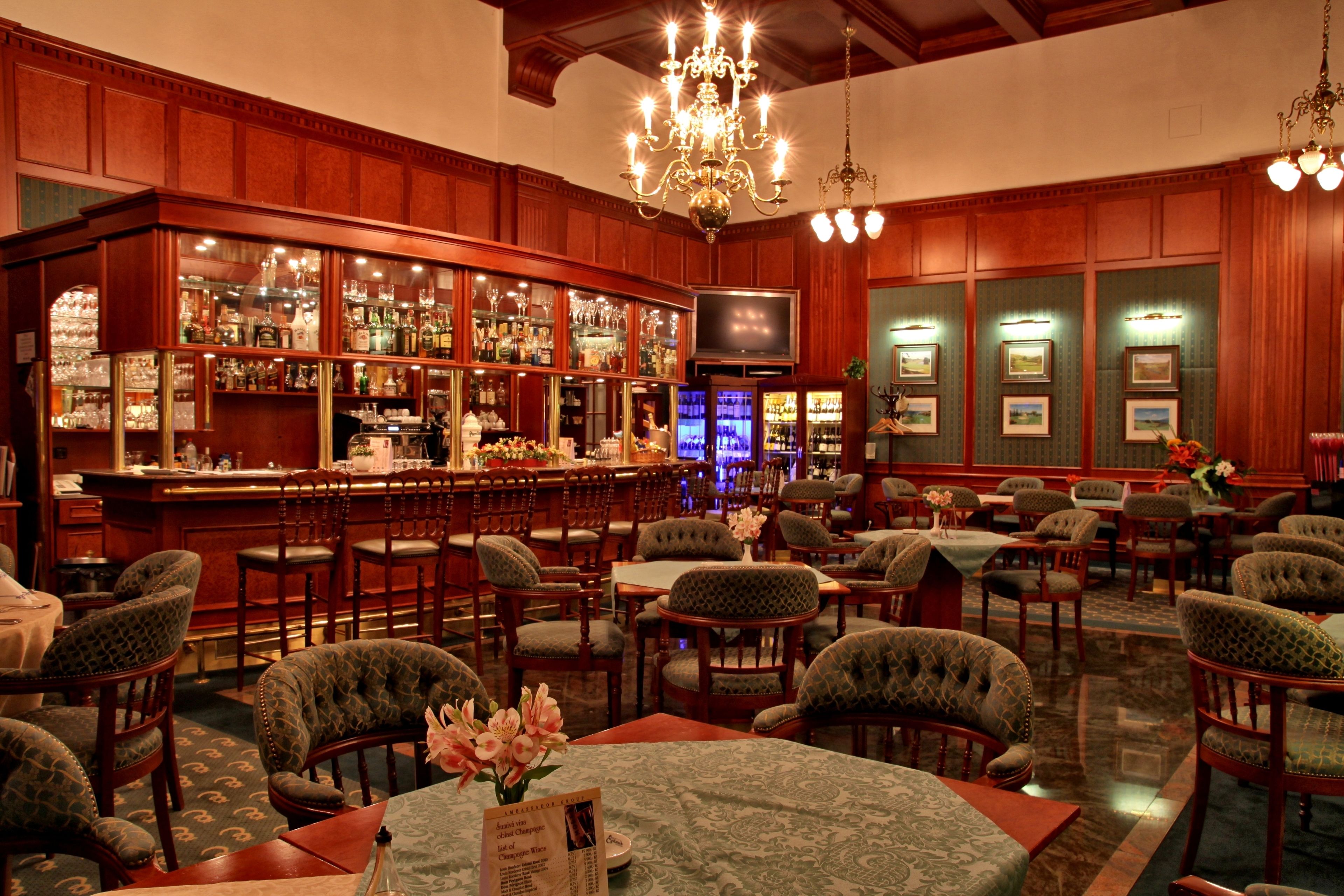 Zona de bar con paneles de madera, un televisor y diversas opciones de asientos.
