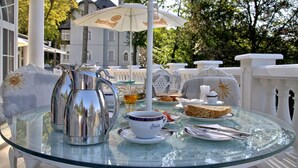 A glass table with a teapot, cups, and plates of food. - Esplanade Spa and Golf Resort (Marianske Lazne)