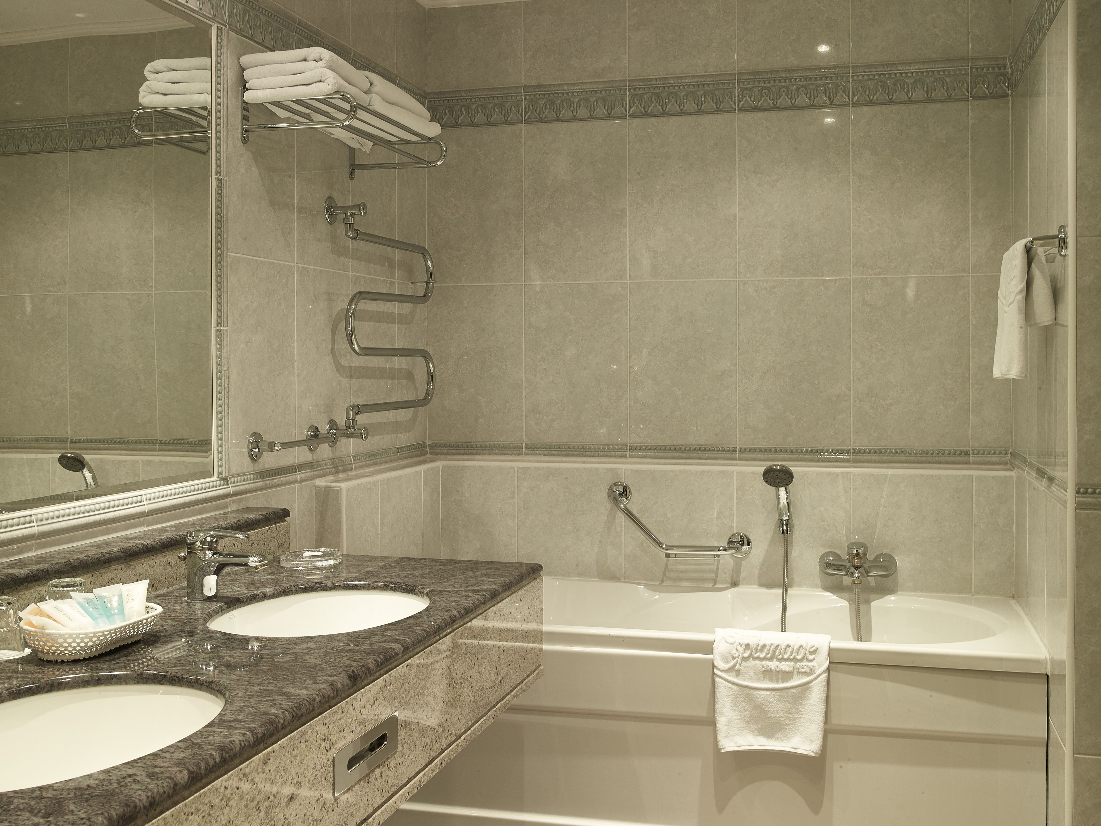 Un baño con dos lavamanos, una bañera y una ducha.