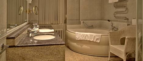 A modern bathroom with a freestanding bathtub, a sink with a vanity, a mirror, and a wicker chair.