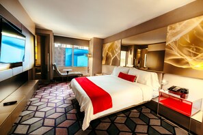 Relax in a stylish room with a large bed, flat-screen TV, and desk area.