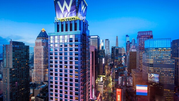 A high-rise hotel with a prominent 'W' logo, surrounded by other tall buildings in a cityscape. - W New York - Times Square (New York)
