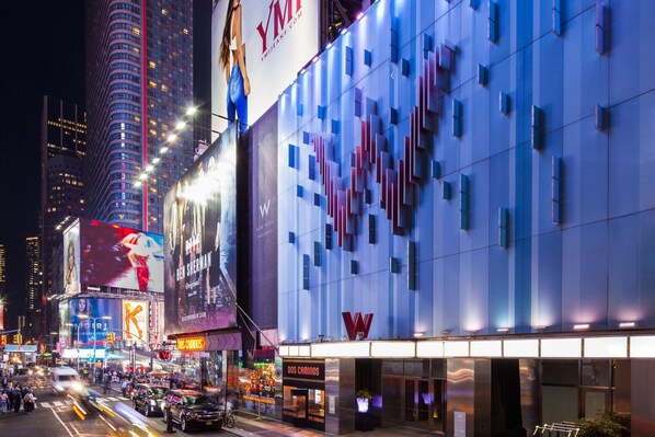 Experience the sleek, contemporary design of this urban hotel, featuring a striking 'W' logo and a modern entrance with a glass door.