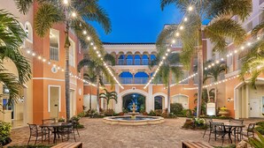 A courtyard with a fountain, outdoor seating, and string lights. - Marriott's Grande Vista (Orlando)