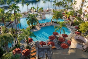 A resort pool area with palm trees, lounge chairs, and umbrellas. - Marriott's Grande Vista (Orlando)