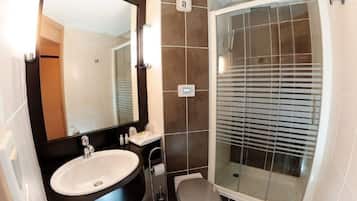 Een douche, milieuvriendelijk toiletgerief, handdoeken