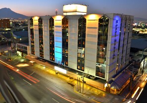 Un hotel moderno con un diseño arquitectónico único, con amplias ventanas y un tanque de agua prominente en el techo.