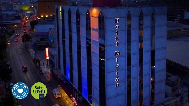 A hotel named 'Hotel Misión' with a prominent sign, located in an urban area with visible traffic and a mountain in the background. - Hotel Misión Monterrey Centro Histórico (Monterrey)