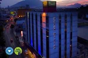 A hotel named 'Hotel Misión' with a prominent sign, located in an urban area with visible traffic and a mountain in the background. - Hotel Misión Monterrey Centro Histórico (Monterrey)