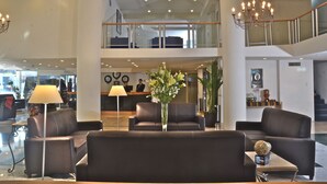 A spacious lobby with a reception desk, multiple seating areas, and a chandelier. - Hotel Misión Monterrey Centro Histórico (Monterrey)