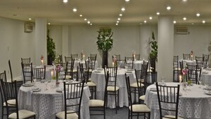 A banquet hall with round tables, chairs, and floral centerpieces. - Hotel Misión Monterrey Centro Histórico (Monterrey)