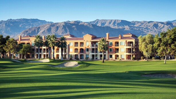 Un campo de golf con un edificio al fondo.