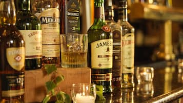 A variety of whiskey bottles on a bar counter.