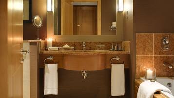 A modern bathroom with a wooden vanity, dual sinks, and a large mirror.