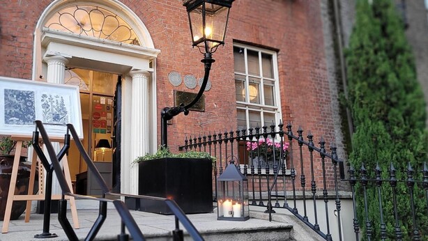 A brick building with a white door, a black metal fence, and a black lantern. - Pembroke Townhouse (Dublin)
