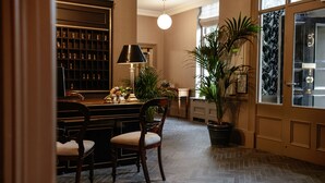 A dining area with a herringbone floor, wooden chairs, a table with a lamp, and a potted plant. - Pembroke Townhouse (Dublin)