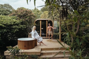 A wooden deck with a hot tub, a wooden pergola, and lush greenery. - Glenapp Castle (Girvan)