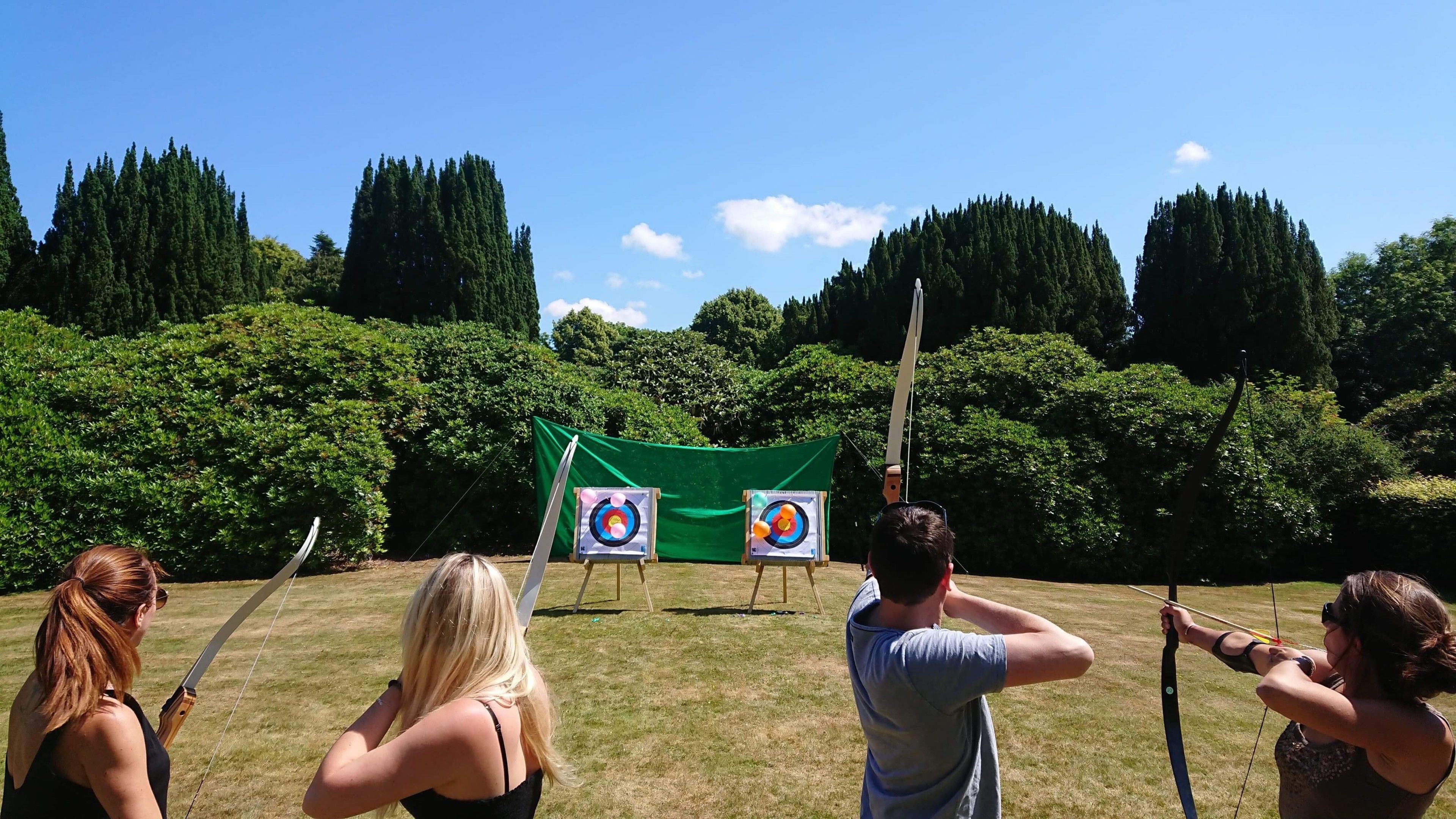 An outdoor archery range with targets and participants.