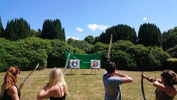 An outdoor archery range with targets and participants.