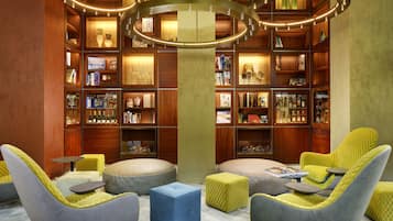 A library with bookshelves, a central pillar, and seating areas.