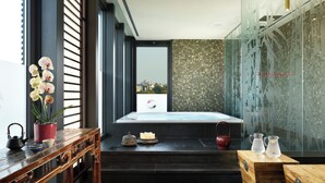 Un spa moderno con un banco de madera, una orquídea en maceta, un jacuzzi y cajas de madera con jarras de agua.