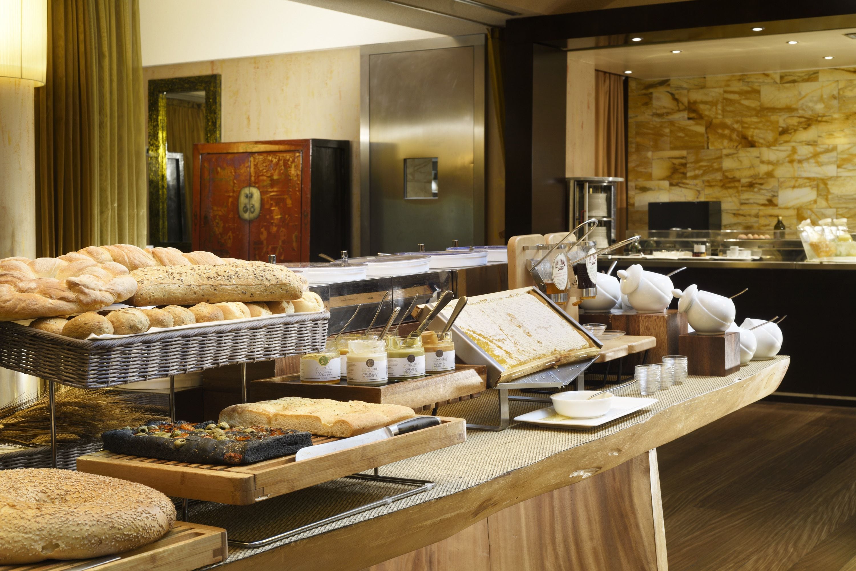 A buffet with various breads, pastries, and spreads.