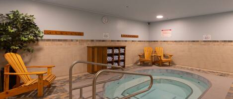 A pool area with a hot tub, wooden chairs, and a potted plant.