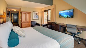 A hotel room with a large bed, a desk, a chair, and a television on the wall. - Blackcomb Lodge (Whistler)