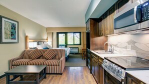 A hotel room with a kitchen, a dining area, and a living room. - Blackcomb Lodge (Whistler)