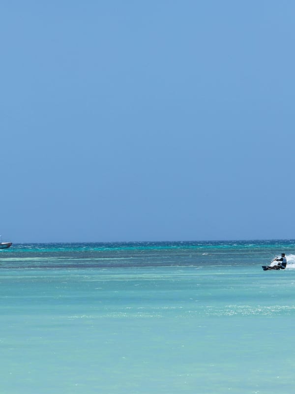 Sulla spiaggia, sabbia bianca, cabine (a pagamento), lettini da mare