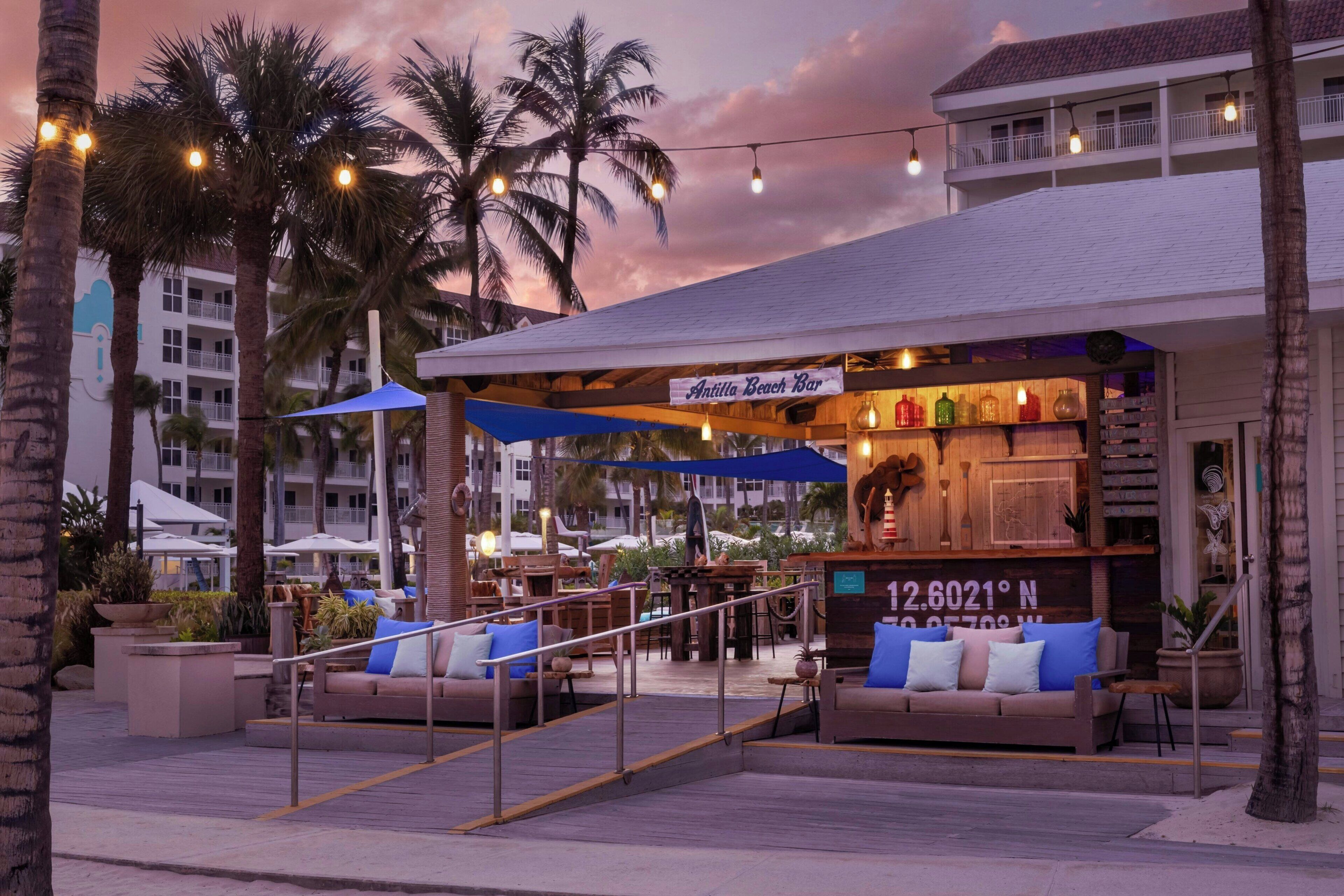 På stranden, hvit sand, strandtelt (mot et tillegg) og solsenger