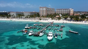A coastal resort with a marina, sandy beach, and hotel buildings in the background.