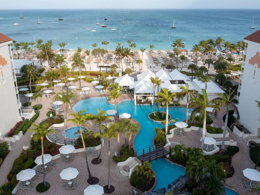 Una piscina al aire libre, camas de piscina con cargo, sombrillas