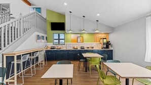 Een moderne keuken met een eethoek, voorzien van een trap, een bar en een bord met de tekst 'Delight in the day'.